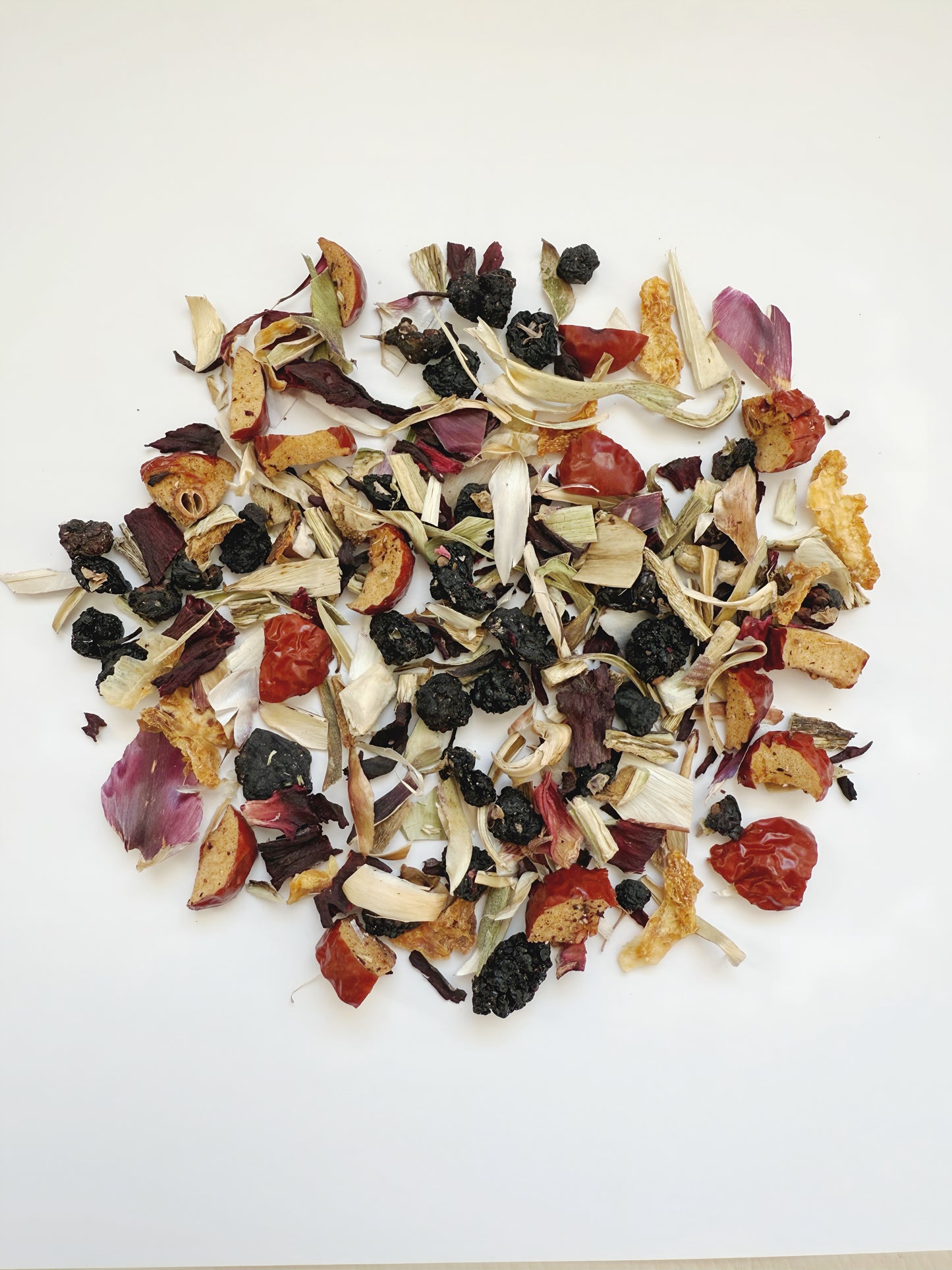Assorted dried fruits and herbs on a white background