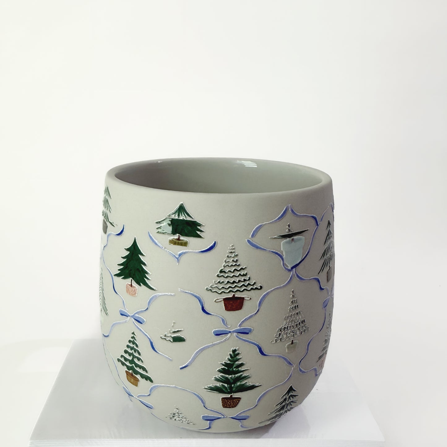 Ceramic mug with decorative tree patterns on a white background