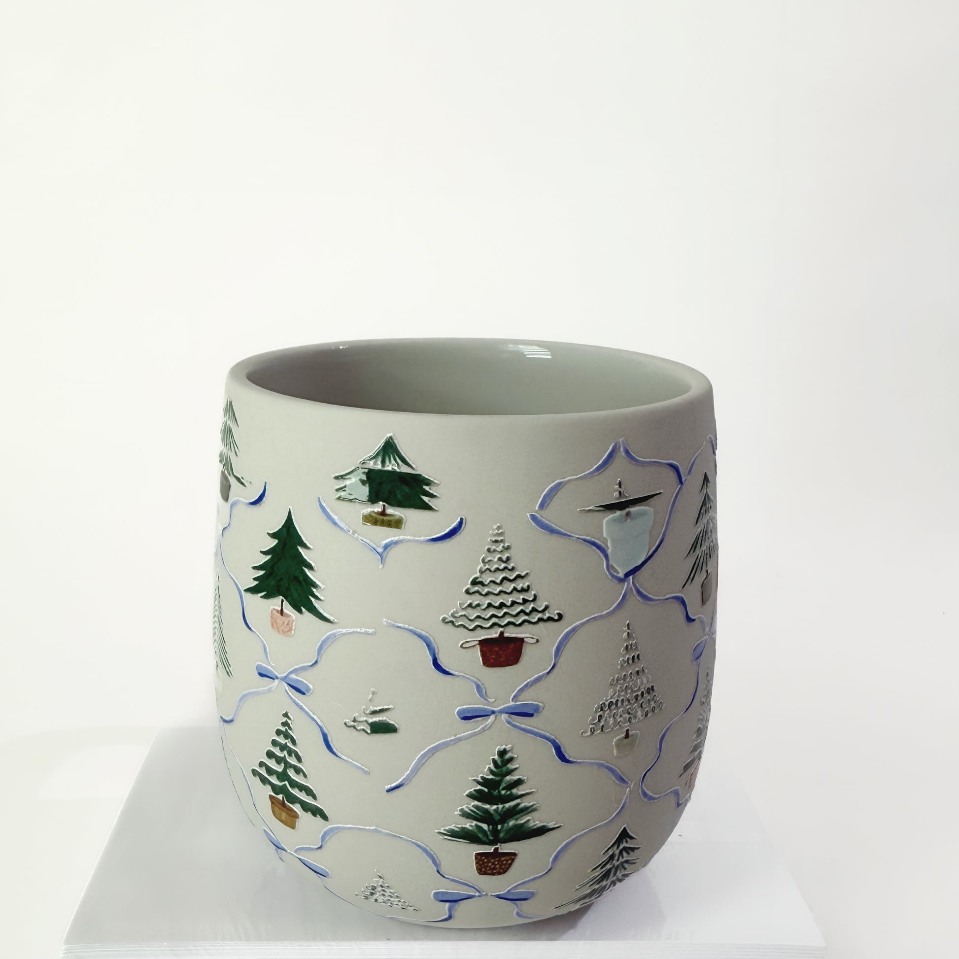 Ceramic mug with decorative tree patterns on a white background