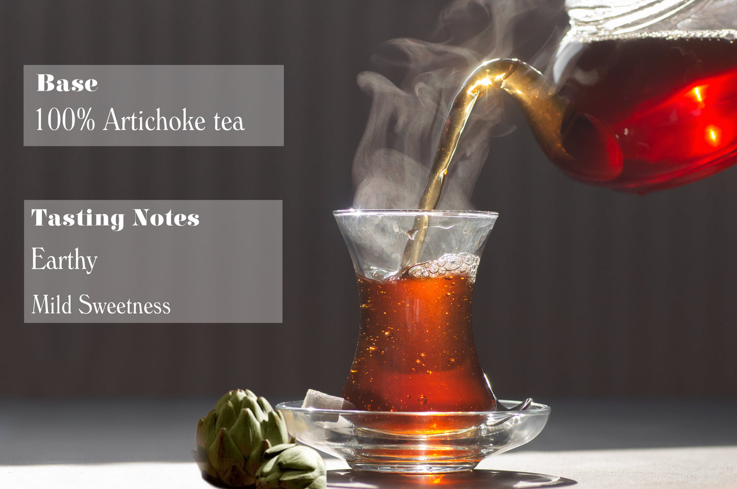 Tea being poured into a glass with artichoke and tea bag on a dark background