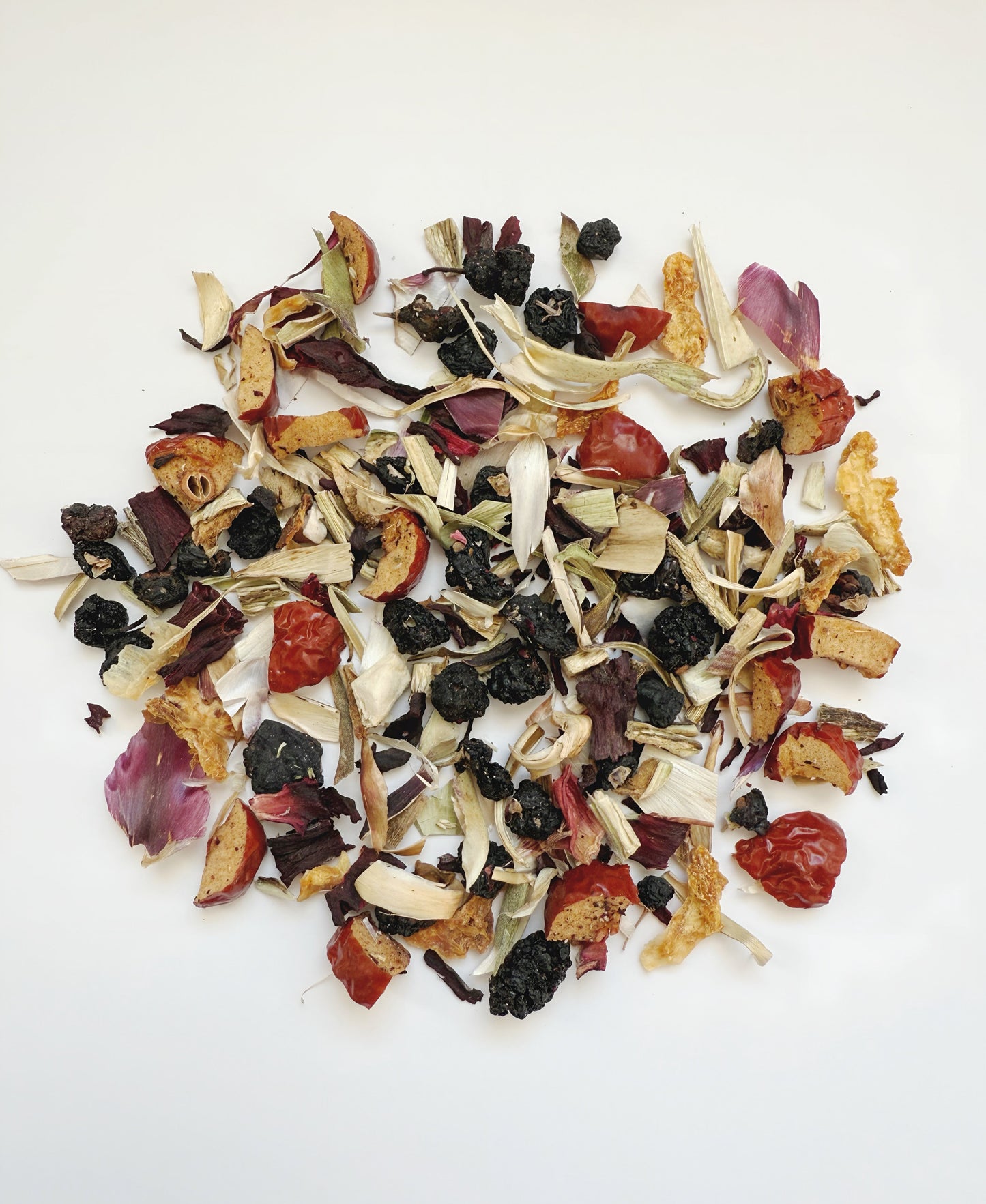 Assorted dried fruits and herbs on a white background
